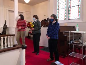 Three members of the choir listen as Chris Psolka is regaled for her music ministry at Christ Church